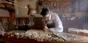 imagen de un hombre luthier construyendo un violín