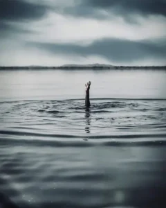 Brazo levantado pidiendo ayuda en lago