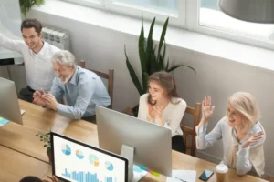 Grupo de personas mayores y jovenes trabajando juntos con ordenadores