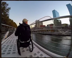 Hombre en silla ruedas cruzando puente
