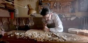 Hombre lutier construyendo un violín