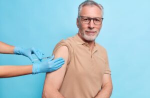 Hombre mayor al que le están poniendo una inyección en el brazo