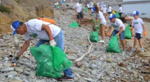 Hombre mayor recogiendo basura en el campo con varios niños