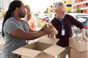 Hombre mayor voluntario colocando alimentos en caja