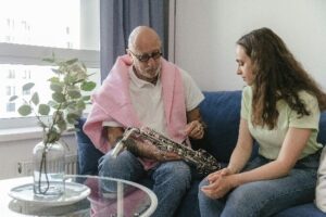 Hombre mayor y chica joven enseñando a tocar saxofón