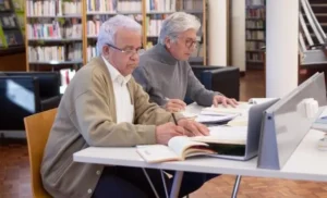 Hombre mayores en biblioteca estudiando