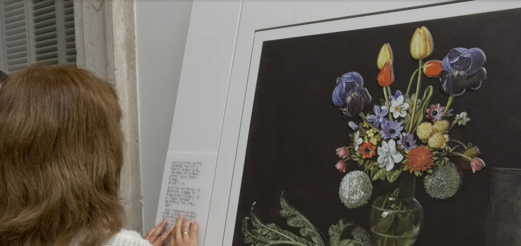 Mujer con discapacidad visual leyendo en braille un cuadro