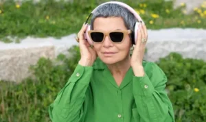 Mujer mayor con gafas de sol escuchando audiolibros