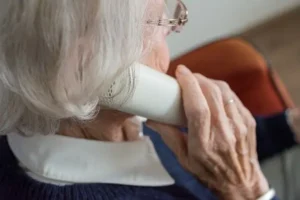 Mujer mayor con teléfono fijo