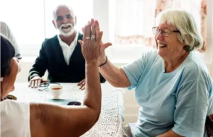 Mujer mayor sonriente chocando la mano con otra persona