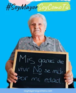 Mujer mayor sonriente sosteniendo una pizarra soy mayor soy como tu