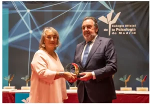 Mujer recogiendo premio psicologia y solidaridad