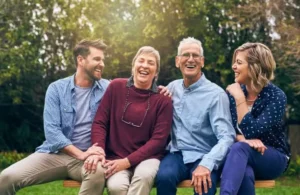 Pareja mayores y jóvenes sentados sonrientes