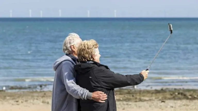 Personas mayores haciendo selfie en la playa