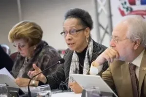 Dos mujeres y un hombre mayores participando en conferencia