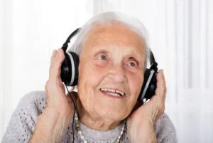 Mujer mayor sonriente oyendo musica con cascos