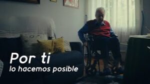 Hombre mayor en silla de ruedas en el salón de casa con poca luz