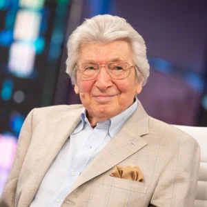 Manuel Alejandro sonriente con camisa azul y americana beige