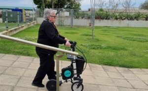 Mujer mayor andando con el apoyo de un andador al aire libre