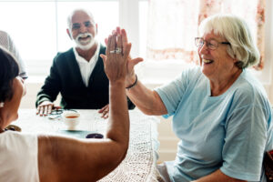 Grupo de personas mayores sonrientes y dos chocando las manos