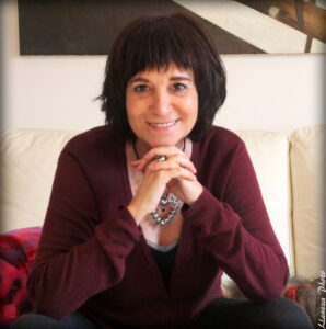 Rosa Montero sonriente mirando a cámara con jersey rojo