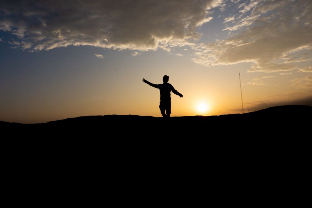 A serene silhouette of a person embracing the sunset in Trujillo, Peru.