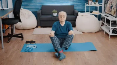 Hombre mayor en salon postura yoga