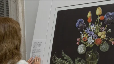 Mujer con discapacidad visual leyendo en braille un cuadro