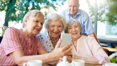 Personas mayores juntos mirando móvil